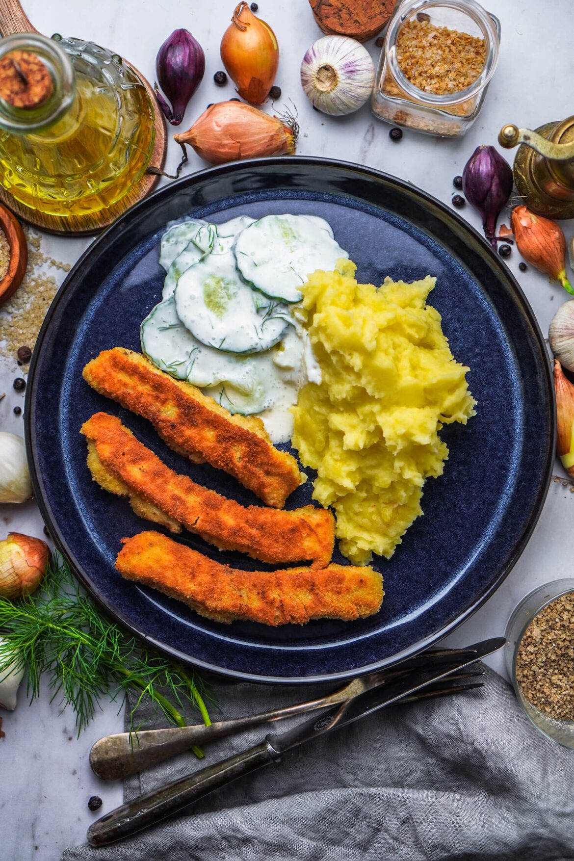 Selbst gemachte Fischstäbchen mit Kartoffelpüree und Gurkensalat