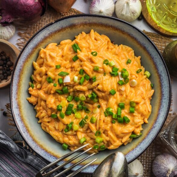 Eine Schüssel mit Curry-Nudeln und oben drauf sind frische Frühlings..