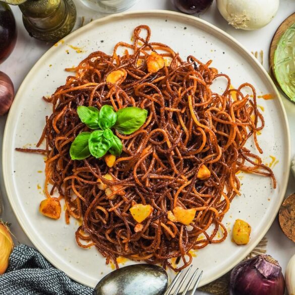 Nudeln mit einer tomatigen Soße, welche in der Pfanne karamellisiert ist. Mit gebratenen Knoblauch, Ansicht von oben