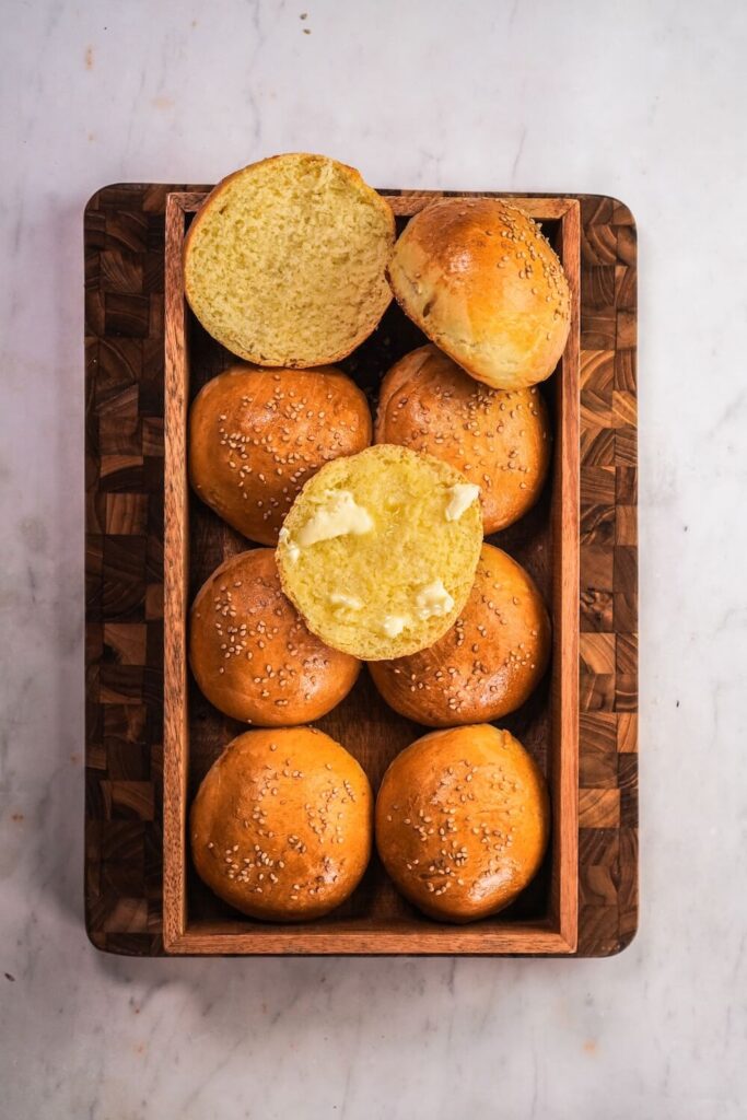Eine Kiste mit Brioche Burger Brötchen, eins ist aufgeschnitten sodass die Struktur erkennbar ist