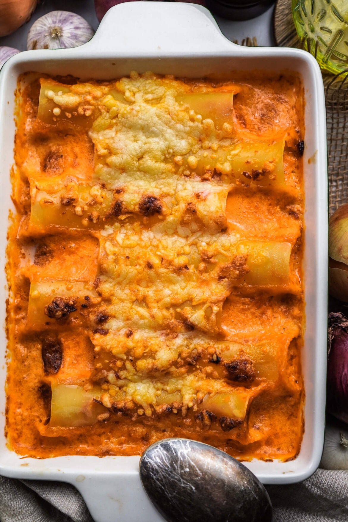 Eine Auflaufform voll mit überbackenen Cannelloni und Soße und geschmolzenen Käse