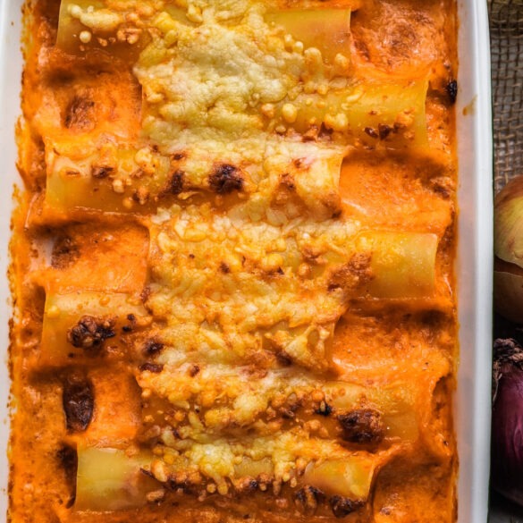 Eine Auflaufform voll mit überbackenen Cannelloni und Soße und geschmolzenen Käse