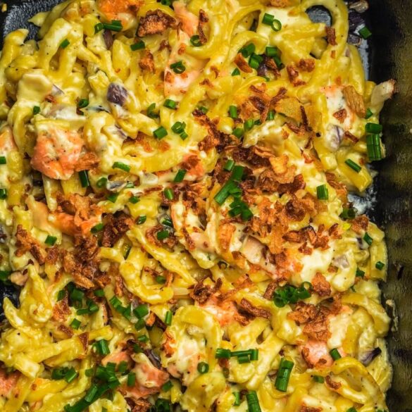 Eine Auflaufform mit Käsespätzle und Ofenkäse mit Schnittlauch und Röstzwiebeln oben drauf